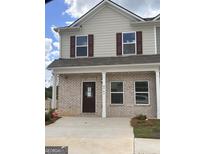 Charming two-story townhome boasts a brick facade, with a covered entrance, and a well-lit walkway at 8747 Lakeview Commons # 1, Jonesboro, GA 30238