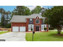Charming two-story brick home with well-manicured lawn and two-car garage in a residential area at 5113 Heritage Oaks Sw Ln, Powder Springs, GA 30127