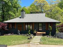 Charming single-story home featuring mature landscaping, well-maintained lawn and attractive front entrance at 921 Oak Dr, Woodstock, GA 30189