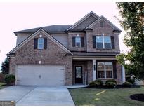 Charming brick two-story home with a two-car garage and well-maintained front yard at 878 W Union Grove Cir, Auburn, GA 30011