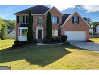 Charming brick two-story home with a well-manicured lawn and attached two-car garage at 5678 Mill View Way, Lithonia, GA 30038
