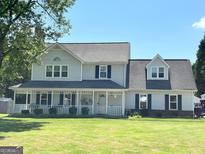 Charming two-story home featuring a welcoming front porch, well-manicured lawn, and classic architectural details at 503 Atwood Cir, Peachtree City, GA 30269