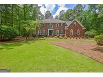 Charming brick home with a well-manicured lawn and mature trees in a desirable neighborhood at 111 Biltmore Trce, Peachtree City, GA 30269
