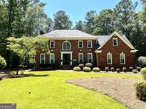 Traditional brick home showcasing a well-manicured lawn and lush landscaping for enhanced curb appeal at 111 Biltmore Trce, Peachtree City, GA 30269