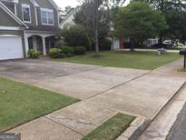 Charming two-story home featuring a spacious driveway, well-maintained lawn, and mature trees at 3639 Cape Ln, Conyers, GA 30013
