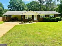 Charming brick home with a well-manicured lawn and a convenient carport at 113 Ausband Dr, Mcdonough, GA 30253