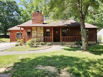 Charming home featuring a stone accent wall and a cozy front porch with wood railing at 6698 Cameron Rd, Morrow, GA 30260