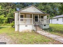Charming cottage-style home with a welcoming front porch and landscaped yard at 5166 Avery Sw St, Covington, GA 30014