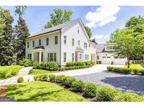 Elegant two-story home with white siding, manicured landscaping, and a spacious driveway leading to a detached garage at 4015 Wieuca Ne Rd, Atlanta, GA 30342