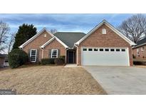 Charming brick home with a well-manicured front yard and attached two-car garage at 410 Oakpark Ter, Mcdonough, GA 30253