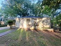 Charming single-story home featuring a covered entry and a lush green lawn, shaded by mature trees at 1901 Clarke Ln, Decatur, GA 30035
