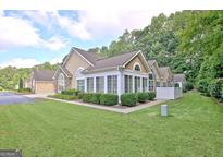 Charming exterior view of home with lush landscaping and a well-maintained lawn on a sunny day at 150 Butterton Ct, Fayetteville, GA 30214