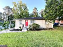 Charming single-story home featuring a bright red door, painted brick, and a well-maintained front lawn at 51 Springside Se Dr, Atlanta, GA 30354