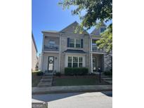 Charming townhouse with a brick facade, balcony, and manicured landscaping at 7699 Cabrini Pl, Fairburn, GA 30213