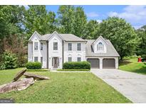 Charming two-story home with white stucco exterior, lush landscaping, and a spacious driveway at 1478 Interlaken Pass, Jonesboro, GA 30238