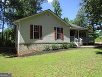Charming single-story home with red shutters, and a cozy front porch at 4382 Highway 42 S, Locust Grove, GA 30248