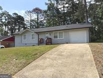 Charming single-story home with a well-maintained lawn and a long driveway at 3339 Clevemont Ct, Ellenwood, GA 30294