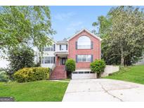 Beautiful two-story brick and white-sided home with a well-manicured lawn, and an attached garage at 182 Spivey Glen Dr, Jonesboro, GA 30236