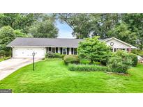 Charming single-story home with well-manicured lawn, mature trees and an attached two car garage at 1226 Pine Knoll, Conyers, GA 30013