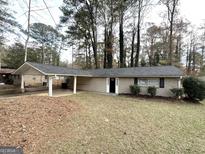 Charming single-story home with a covered carport and well-maintained front yard at 310 Flagstone Sw Dr, Atlanta, GA 30331