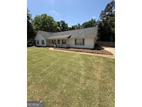 Charming single-story home with a well-manicured lawn, inviting porch, and classic blue shutters at 3005 Ryan Rd, Locust Grove, GA 30248