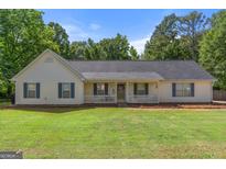 Charming single-story home featuring a welcoming front porch and well-maintained lawn and mature landscaping at 3005 Ryan Rd, Locust Grove, GA 30248