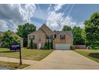 Lovely two-story brick home with mature trees, a well-manicured lawn, and a two car garage at 823 Hennepin Ter, Mcdonough, GA 30253