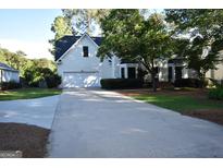 Charming home with a two-car garage and a long driveway in a wooded suburban setting at 207 Tiverton Trl, Peachtree City, GA 30269