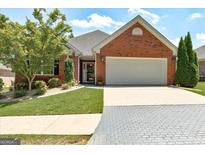 Charming brick home with well-manicured lawn, inviting entrance, and a two-car garage at 273 Prominent Loop, Mcdonough, GA 30253