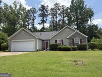 Charming single-story home with a well-maintained lawn and a combination of stone and siding exterior at 3505 Saddle Creek Ln, Ellenwood, GA 30294