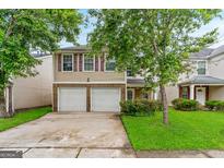 Inviting two-story home featuring a two-car garage and well-maintained front yard at 5865 El Segundo Way, Atlanta, GA 30349