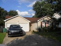 Charming single-Gathering home with a two-car garage and a well-maintained front yard at 4032 Ward Lake Trl, Ellenwood, GA 30294