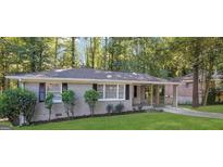 Charming single-story home featuring a well-manicured lawn and mature trees at 2364 Farley St, East Point, GA 30344