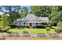 Charming home featuring a spacious porch, manicured lawn, and a classic white picket fence at 441 Crumbley Rd, Mcdonough, GA 30252