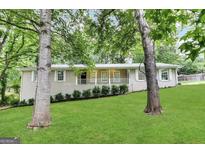 Charming single-story home features a welcoming front porch, fresh lawn and tidy landscaping at 6236 Shallow Creek Ln, Douglasville, GA 30135