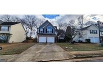 Charming two-story home features a two-car garage, lovely landscaping, and welcoming curb appeal at 1230 Chris Lake Dr, Lawrenceville, GA 30046