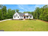 Stunning two-story home with white siding, black trim, a dark roof, and a well-manicured lawn at 155 Grace Hope Dr, Brooks, GA 30205