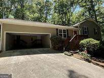 Charming home featuring a garage, landscaped front yard, and inviting entrance with wood stairs at 261 Sally Duke Dr, Whitesburg, GA 30185