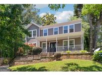 Charming two-story home featuring a welcoming front porch and well-maintained landscaping with mature trees at 4031 E Meadow Dr, Duluth, GA 30096