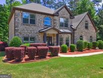 Beautiful brick home featuring manicured landscaping and a well-maintained lawn at 2360 Braunsroth Ln, Hampton, GA 30228