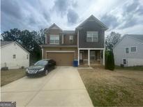Charming two-story home with a two-car garage, lovely yard, and well-maintained landscaping at 5470 Hilltop Pass, Fairburn, GA 30213