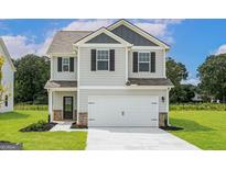 Charming two-story home featuring a two-car garage and well-manicured lawn at 303 Limestone Circle, Conyers, GA 30013
