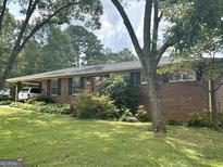Charming brick home featuring a well-maintained lawn and covered parking at 2334 Connally Dr, East Point, GA 30344