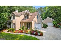 Charming two-story home with a two car garage, mature trees, and colorful flower beds at 210 Farr Lake Dr, Tyrone, GA 30290