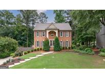 Charming brick two-story home with a manicured lawn and beautiful landscaping at 405 Woodbrook Way, Lawrenceville, GA 30043