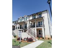 Attractive townhouses with welcoming front porches, complemented by well-maintained landscaping and 'For Sale' signage at 3564 Shore Wood Ave, Lawrenceville, GA 30044