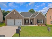 Charming brick home with a well-manicured lawn, two-car garage, and inviting front porch at 1243 Polk Xing, Mcdonough, GA 30252