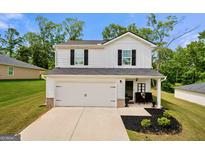 Charming two-story home boasts a white exterior, a well-manicured lawn, and inviting curb appeal at 340 Indian Lake Trl, Villa Rica, GA 30180
