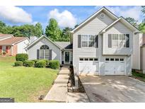 Charming two-story home with a two-car garage, landscaped front yard, and inviting entrance at 5832 Whitney Way, Rex, GA 30273