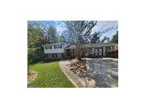 Charming two-story home with a lush front yard, mature trees and a welcoming driveway at 3140 Kipling Dr, Powder Springs, GA 30127